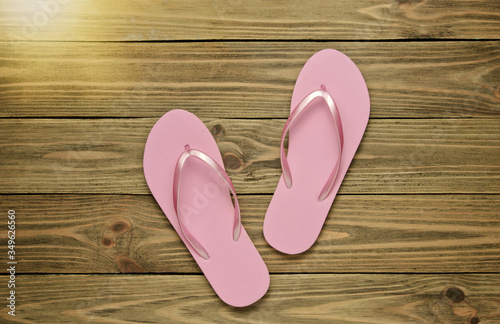 Tropical beach lifestyle. Pink Flip flops on wooden background. Summer background. Top view