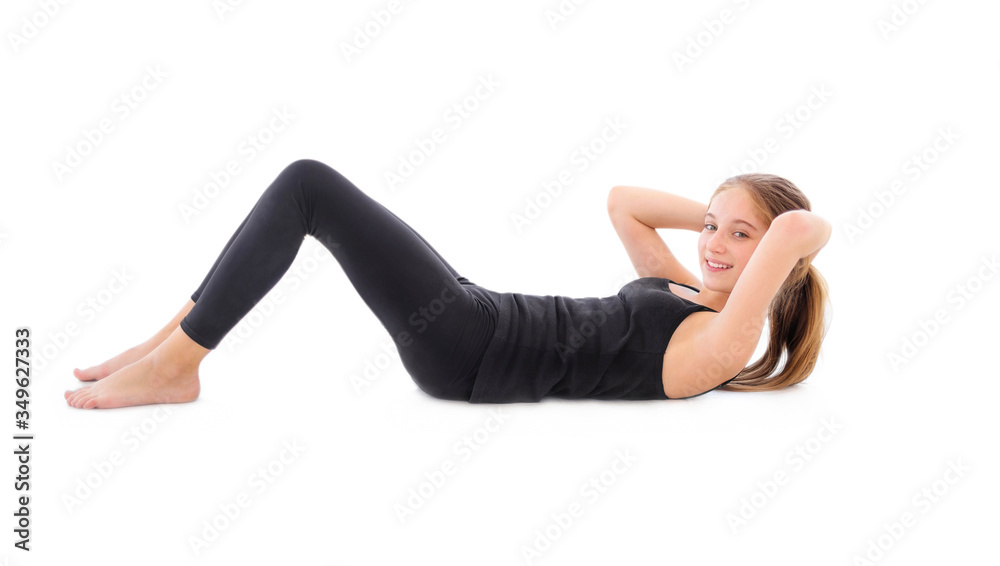 Pretty young girl doing ab exercises on a floor isolated on a white background Pretty young girl doing ab exercises on a floor isolated on a white background