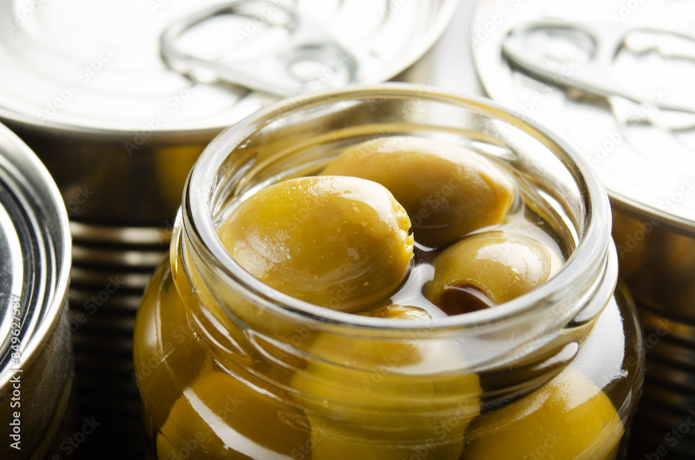 Canned green olives in just opened glass mason jar. Non-perishable food Canned green olives in just opened glass mason jar. Non-perishable food