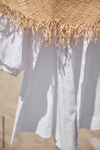 Obraz na płótnie Straw hat, white blouse on a beach w salonie