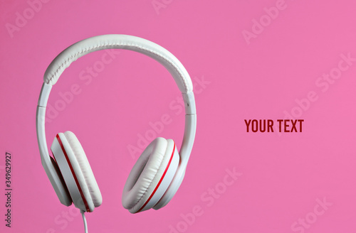 White classic wired headphones isolated on pink background. Retro style. Minimalistic music concept. Copy space