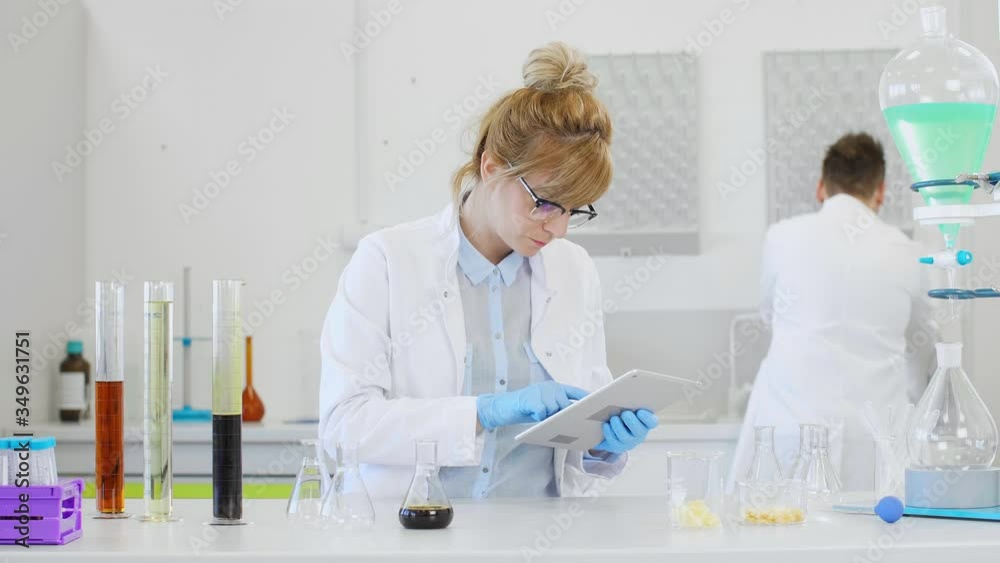 Chemist working with hemp CBD oil and tablet in laboratory Chemist working with hemp CBD oil and tablet in laboratory