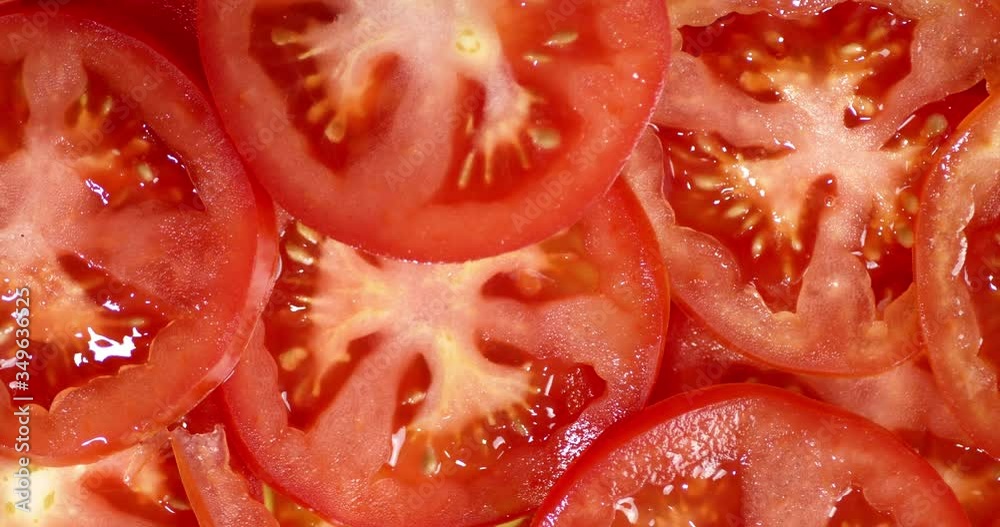 Slices of ripe tomato rotate slowly. Slices of ripe tomato rotate slowly.