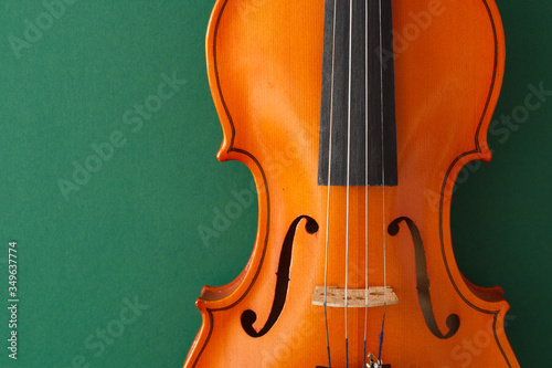 Classical music concert poster with brown color violin on dark green background with copy space for your text
