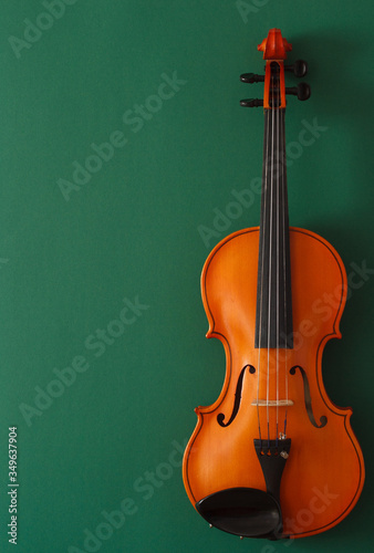 Classical music concert poster with brown color violin on dark green background with copy space for your text
