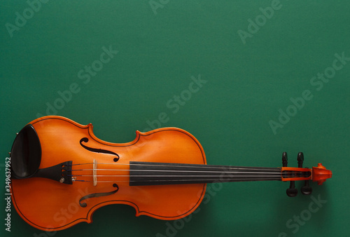 Classical music concert poster with brown color violin on dark green background with copy space for your text
