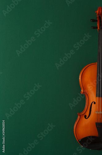 Classical music concert poster with brown color violin on dark green background with copy space for your text
