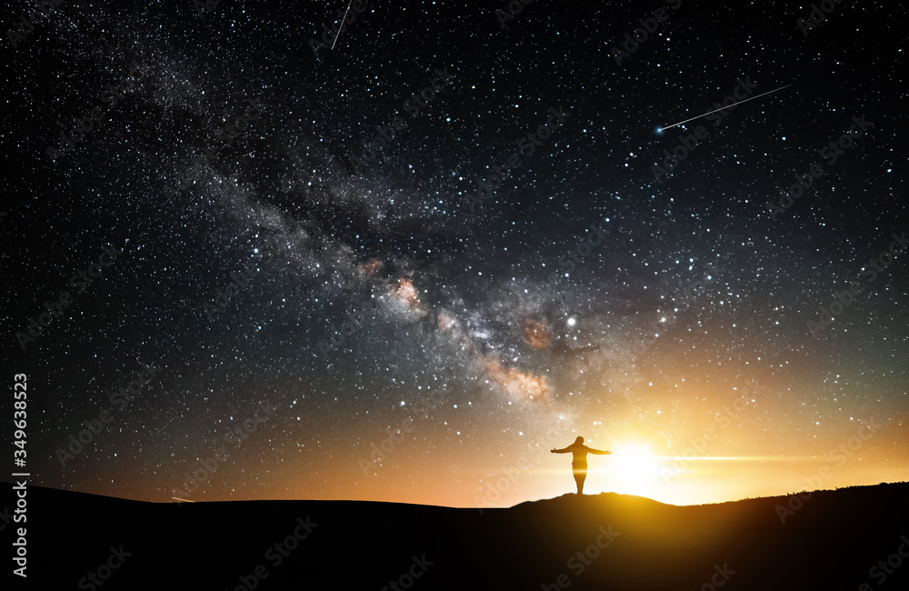 Beautiful starry night, girl silhouette with a camera looking at the Milky Way galaxy.