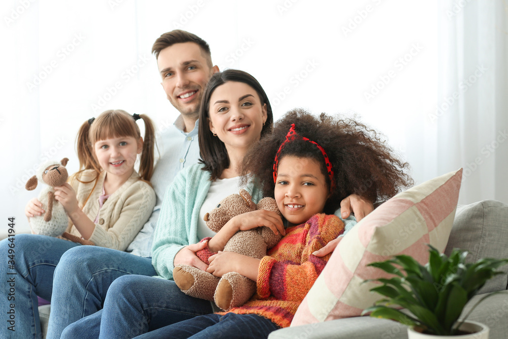Happy couple with little adopted children at home Happy couple with little adopted children at home