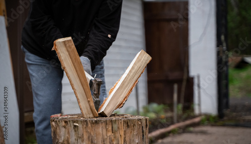 Tableau sur toile Man splitting log on chopping block with axe. Moscow