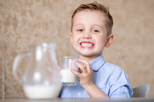 little boy enjoys drinking milk from a mug.