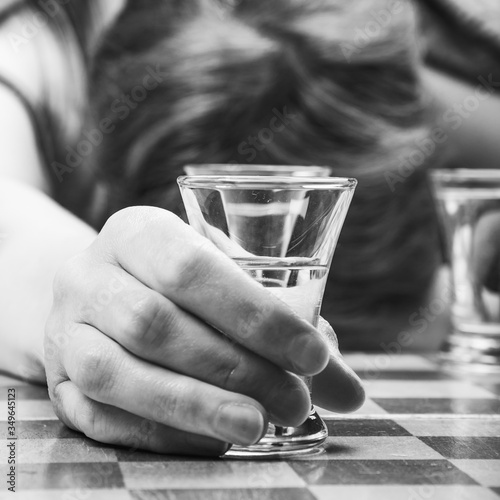 Valokuva Woman sleeping behind a chessboard with a glass of vodka in her hand - alcoholis