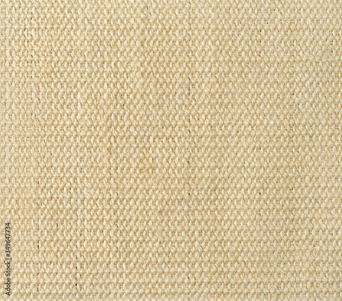 New wicker jute mat texture. Floor covering woven from beige coarse thick fibers. Plain weave backgound. Rustic abstract pattern.