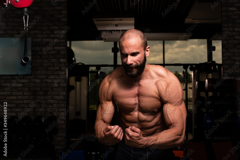 Muscular Man Flexing Muscles In Gym Muscular Man Flexing Muscles In Gym