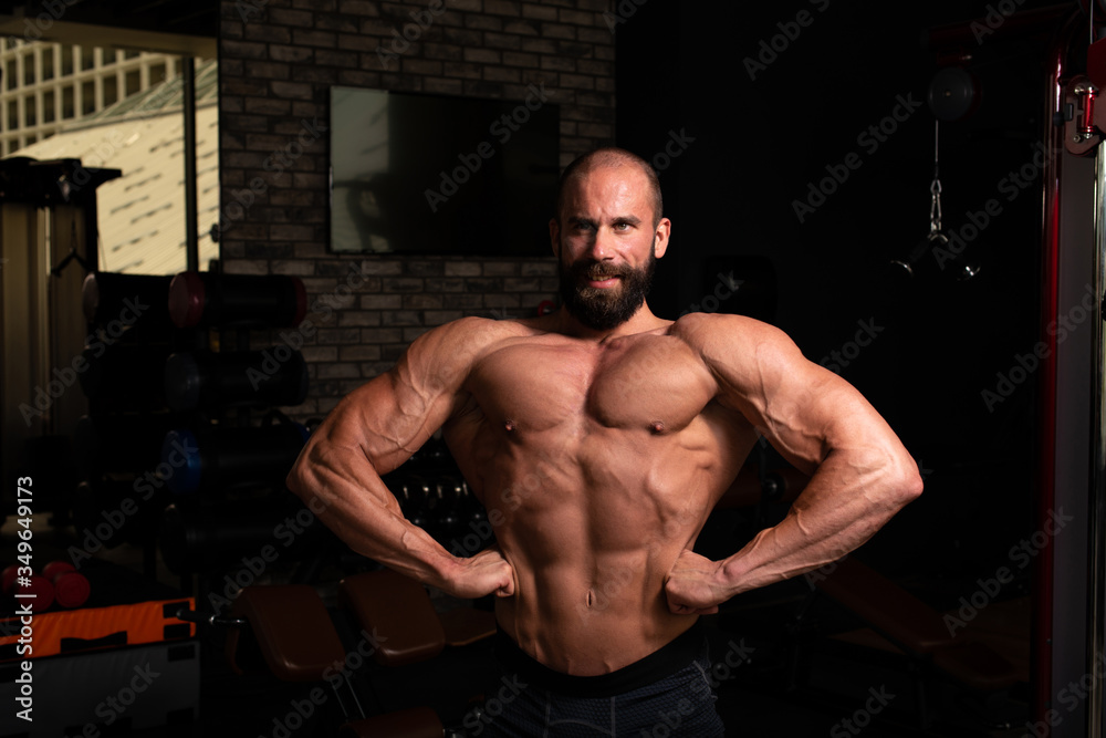 Handsome Muscular Man Flexing Muscles In Gym Handsome Muscular Man Flexing Muscles In Gym