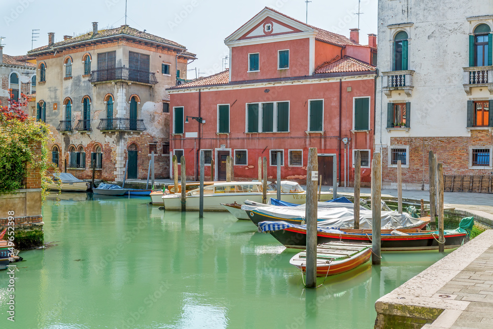 Small boats stand in the middle of Venice at a dock
