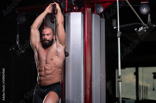 Muscular Man Exercising Triceps On Machine