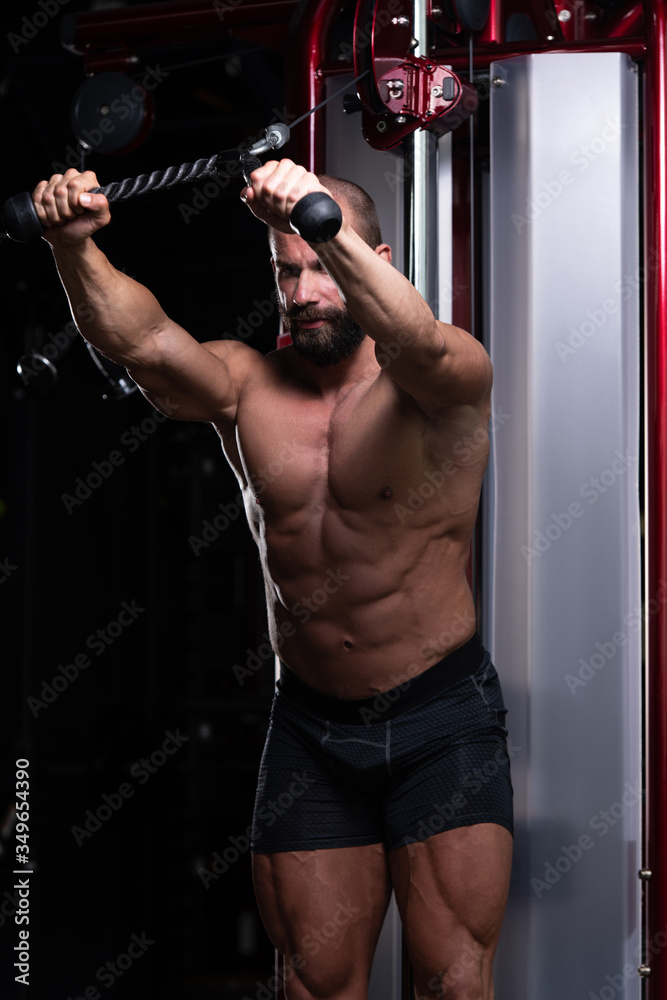 Muscular Man Exercising Triceps On Machine