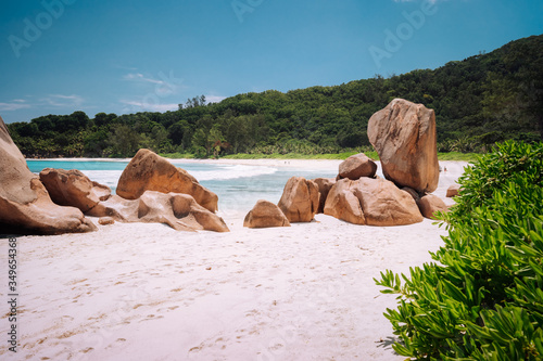 Beautifully shaped granite boulders in the turquoise ocean lagoon and a perfect white sand at Anse Coco, La Digue island, Seychelles