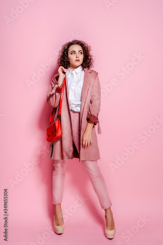 Young elegant woman in trendy pink coat. isolated studio shot.