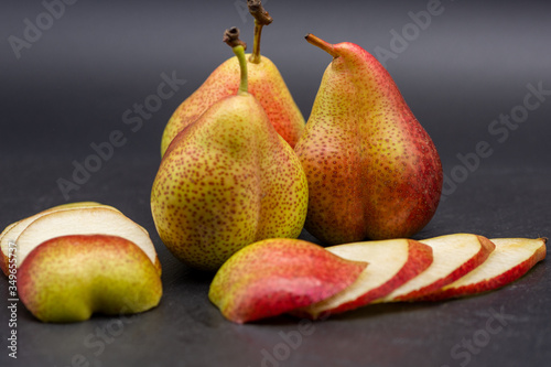whole pears and slices of pear on black