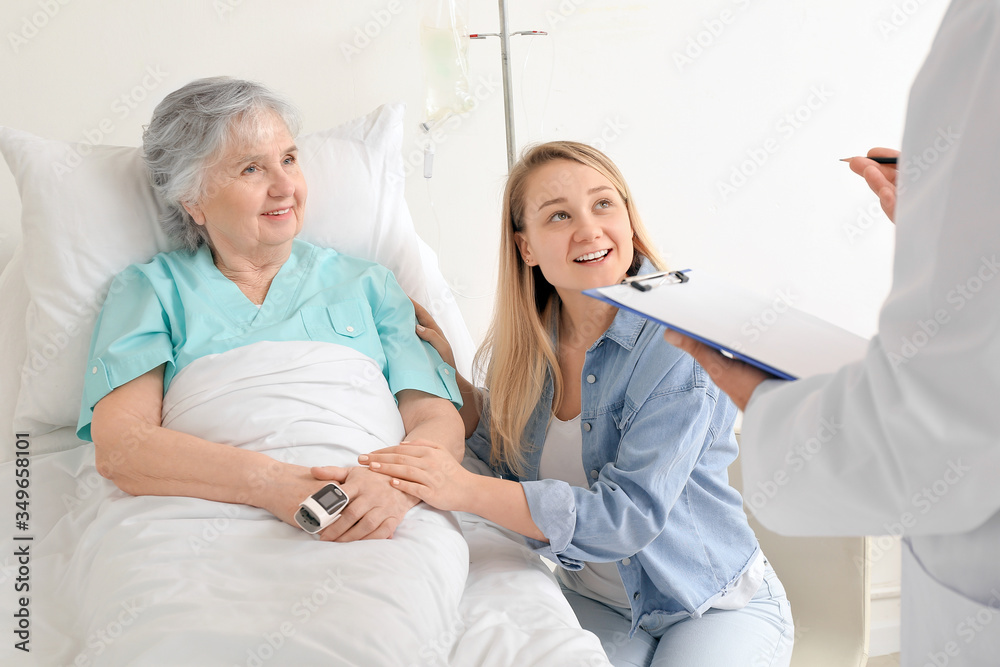 Fototapeta premium Young woman visiting her grandmother in hospital