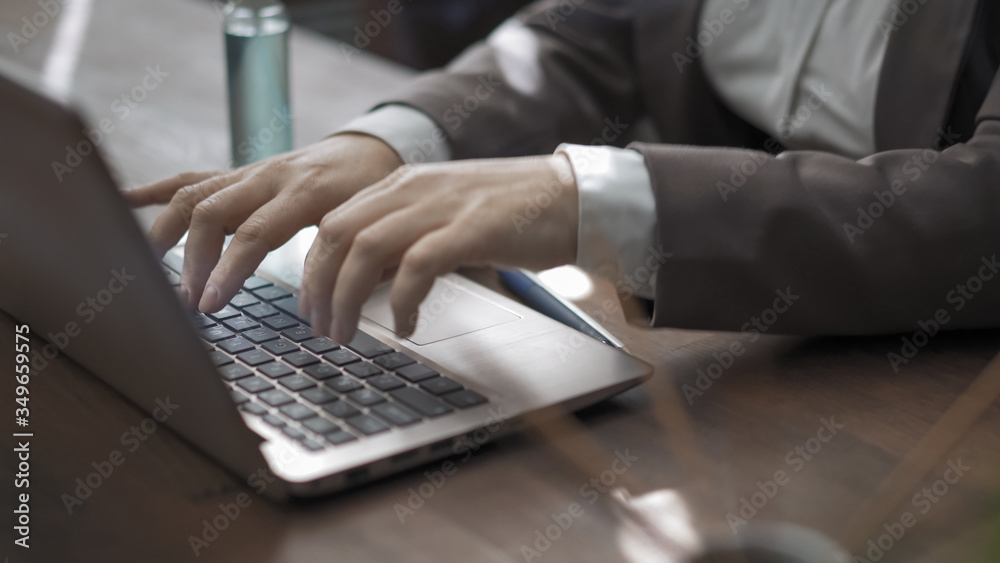 Hands of businesswoman typing on a computer keyboard. Woman at workplace with antiseptic spray and incense sticks on it Hands of businesswoman typing on a computer keyboard. Woman at workplace with antiseptic spray and incense sticks on it