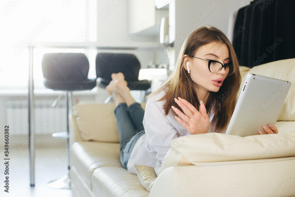 Φωτογραφία Video call conference, relaxed girl lying on sofa having a video chat on digital tablet at home, european woman talking video call, female using online telecommunication