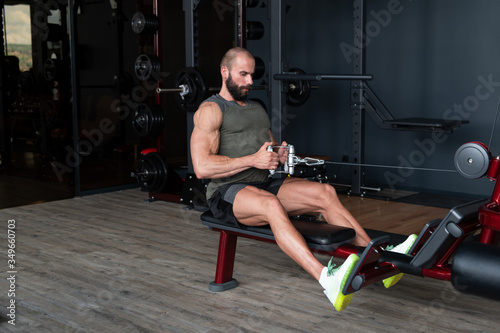 Muscular Man Exercising Back On Machine