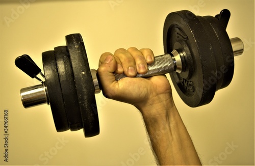 closeup of a man's hand lifting weights to build muscles