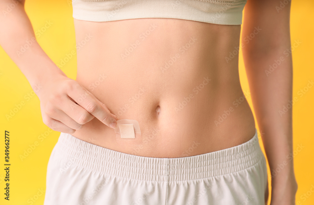 Young woman with contraceptive patch on color background, closeup Young woman with contraceptive patch on color background, closeup