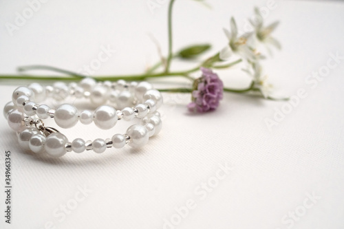 White bracelet on the table with flowers