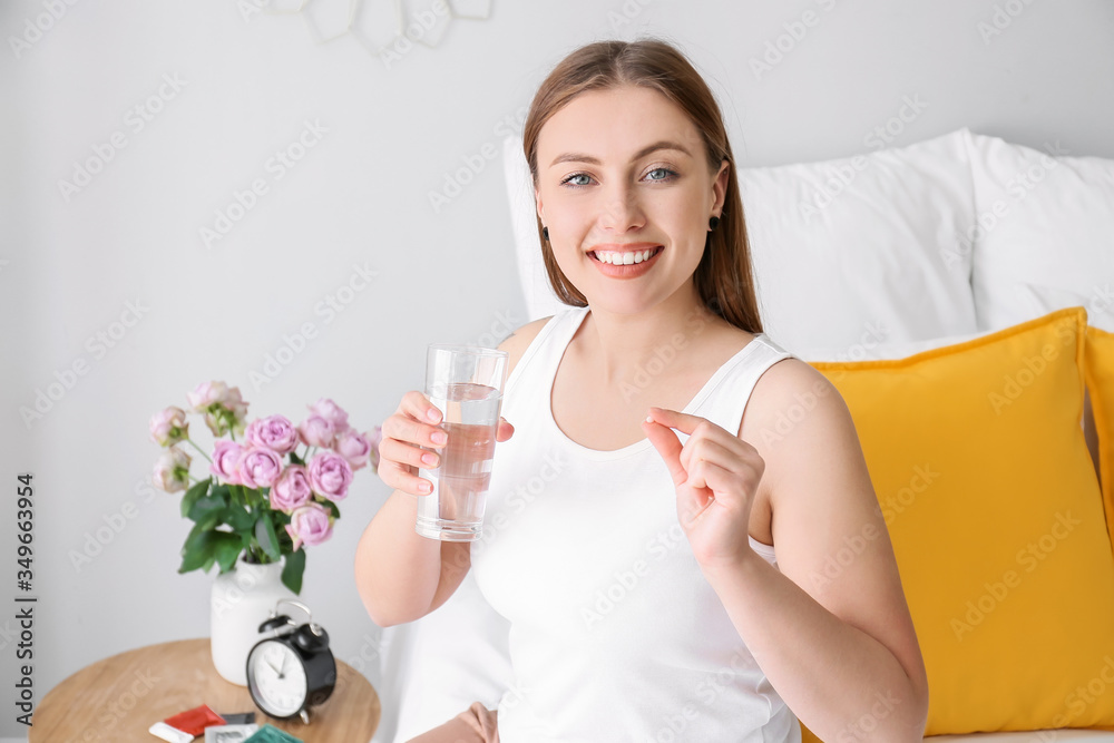 Young woman taking birth control pills at home Young woman taking birth control pills at home