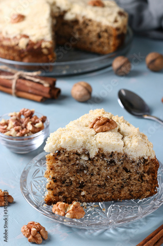 Homemade crumb cake with walnuts and cinnamon in plate on light blue background  ready to eat  closeup  Vertical format