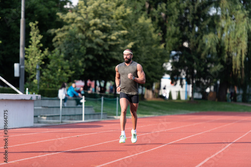 Young Male Athlete Running on Track © Jale Ibrak