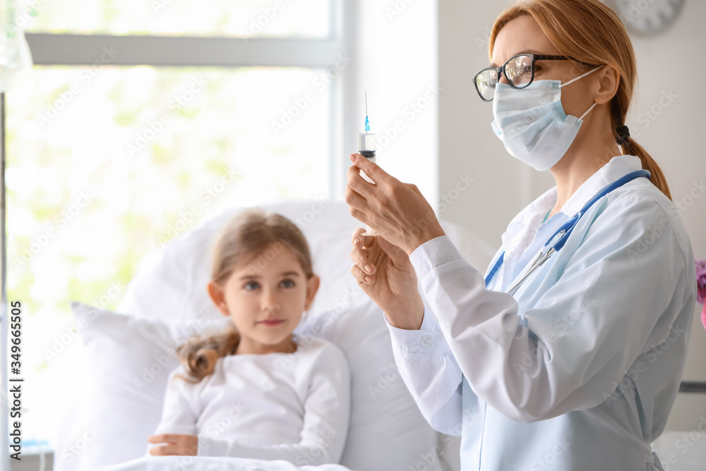 Female doctor working with little girl in hospital room Female doctor working with little girl in hospital room