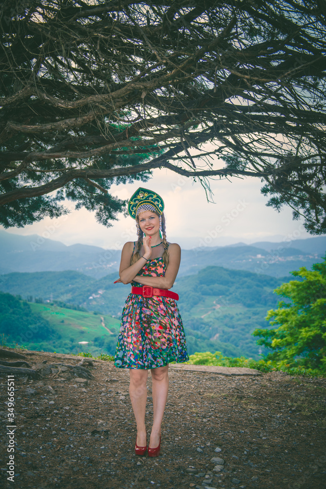 A young woman in a colored dress with a red belt and red shoes with a cocoanut on her head