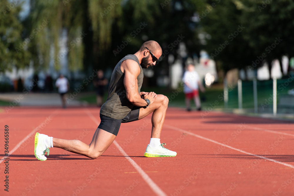 Young Fitness Man Runner Stretching Legs Before Run