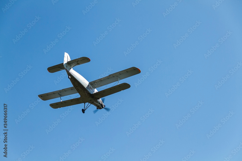a retro biplane flying at high speed high in the air against a blue, cloudless sky. a retro biplane flying at high speed high in the air against a blue, cloudless sky.