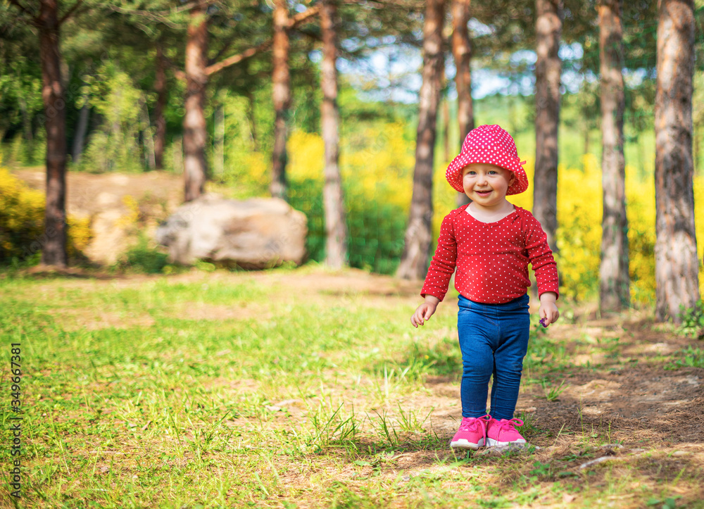 Little girl plays on nature against the background of spring greenery. Little girl plays on nature against the background of spring greenery.