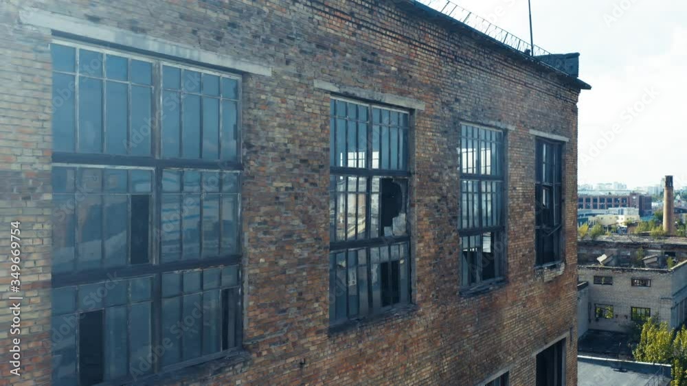 Abandoned old factory ruins with broken windows. Old industrial building for demolition. Aerial side view. Close-up shot Abandoned old factory ruins with broken windows. Old industrial building for demolition. Aerial side view. Close-up shot