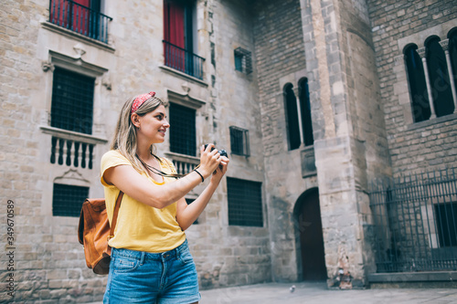 Delighted traveling woman taking photos on camera