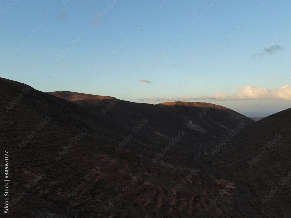 Naklejka premium Sunset between mountains and ravines