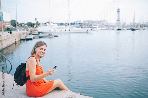 Joyful female traveler surfing Internet on smartphone in harbor © GalakticDreamer