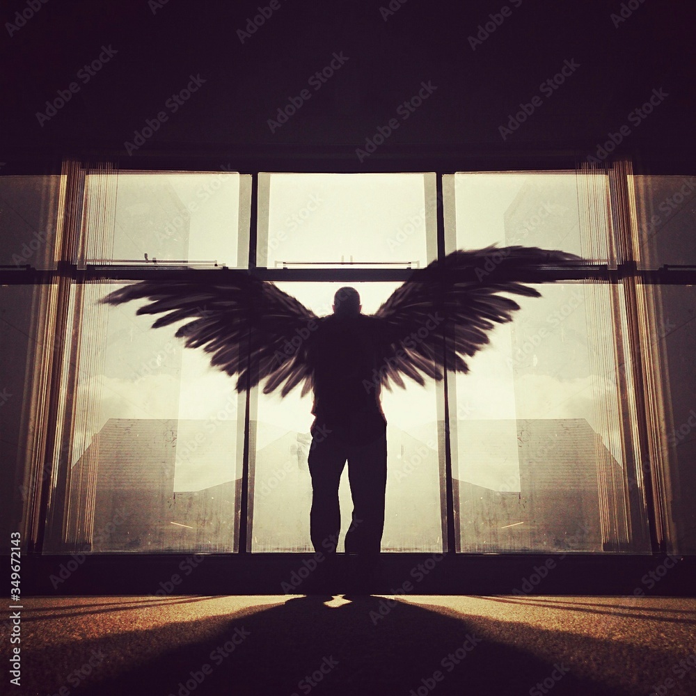Silhouette Man With Wings Standing In Front Of Window Stock Photo ...
