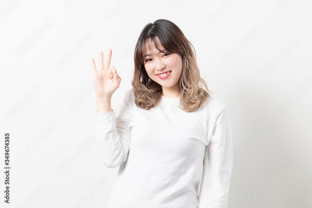 OKサインをポーズをする若い女性