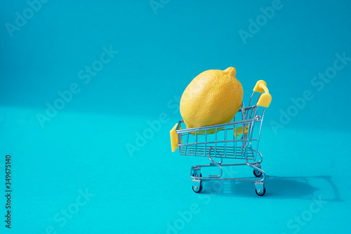 Lemon in the shopping trolley, vitamins. Health and vitaminization. Minimalism. photo