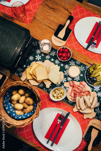 Canvas Print Traditional swiss food called raclette with melting cheese, cooked potatoes and grilled meat