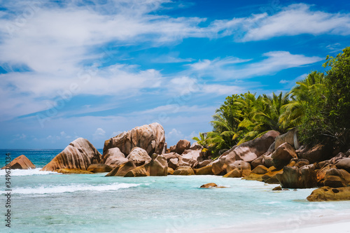 Beautifully shaped granite boulders, shallow tropical lagoon at pristine anse Cocos beach, La Digue island, Seychelles