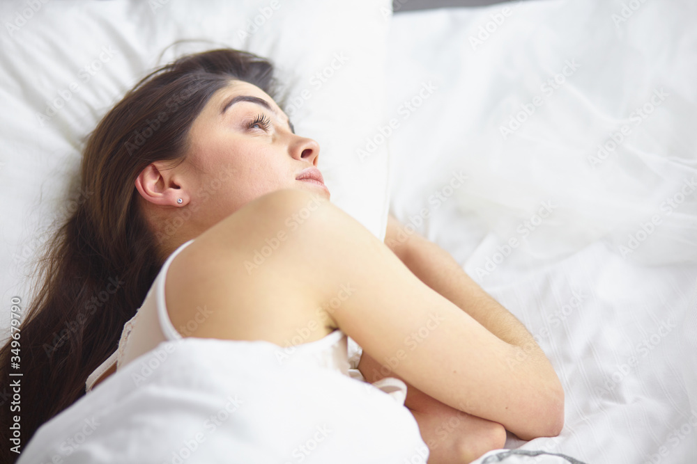 beautiful young woman basking in bed in the morning. Beautiful beautiful young woman basking in bed in the morning. Beautiful